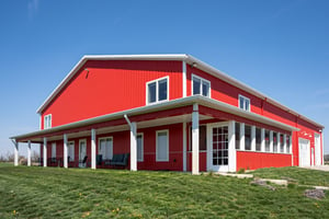 Red two-story barndominium with porch