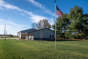 Grey pole barn home with attached shop